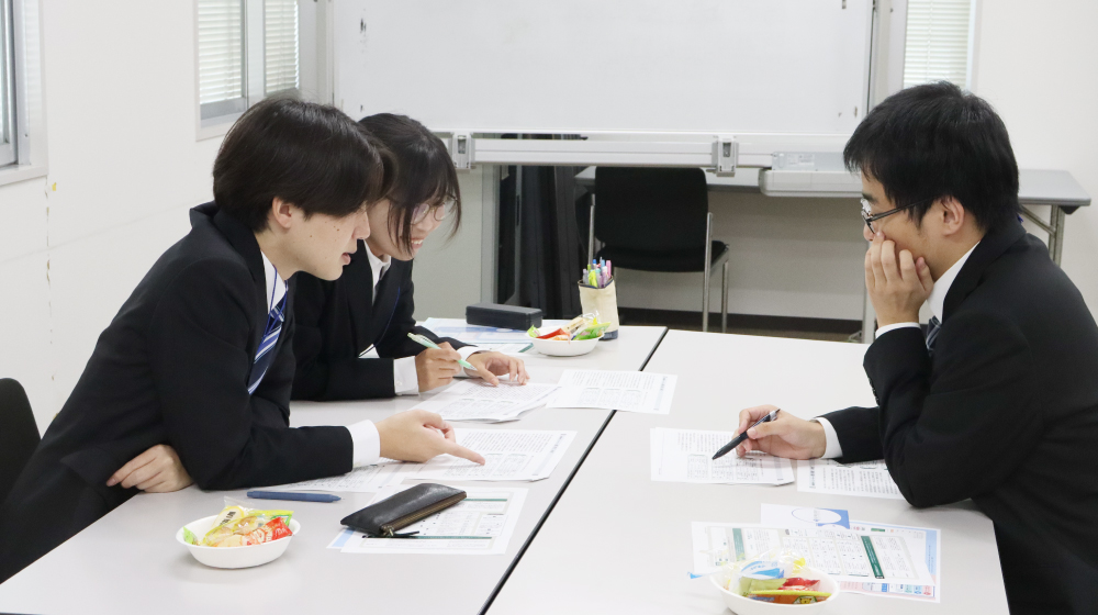 内定者同士が資料を見ながら話し合う様子。和やかな雰囲気の中でディスカッションを行っている。