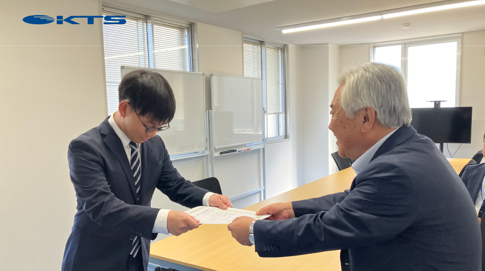 ケイティーエスの内定式で、代表が内定証書を手渡す場面。