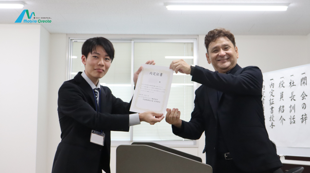 モバイルクリエイト内定式で、代表から内定証書を受け取る内定者。