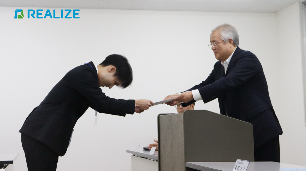 FIGグループのREALIZEにて、代表が内定証書を手渡す様子。