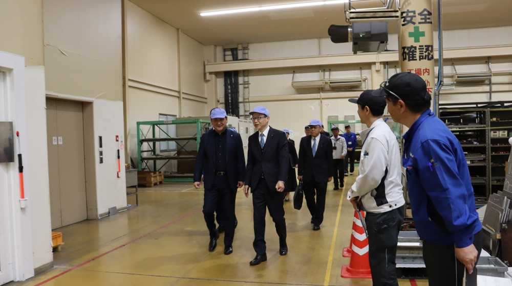 REALIZE株式会社の工場を視察する様子。関係者が製造現場を歩きながら見学している