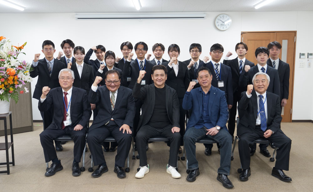 FIGグループ合同入社式において、役員と新入社員が並び記念撮影を行う様子。