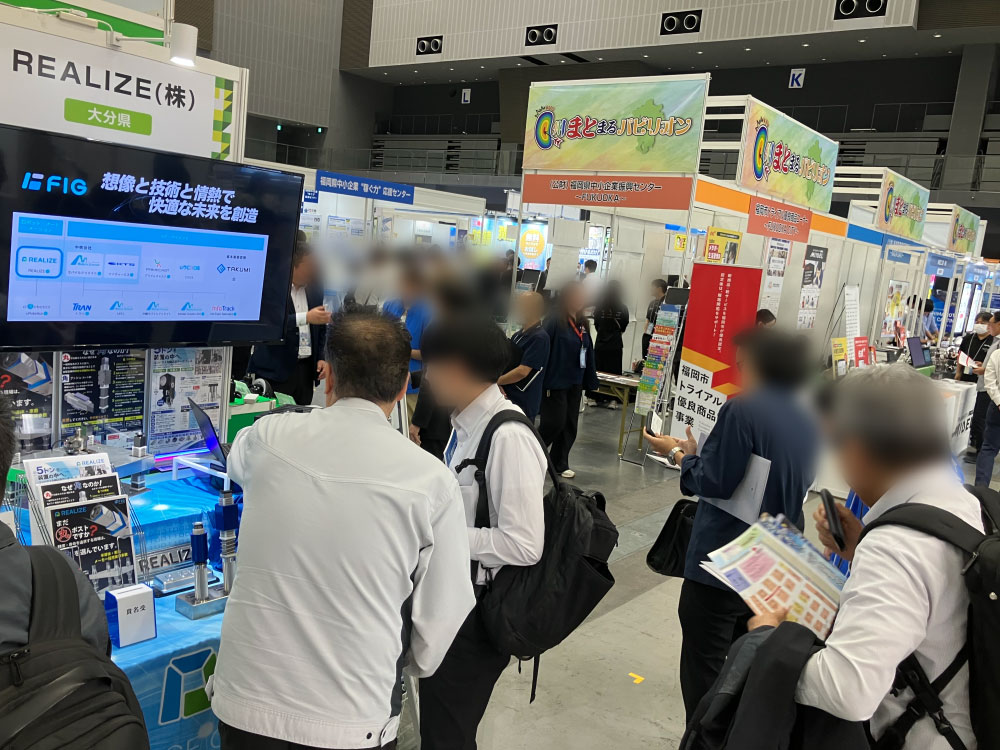 モノづくりフェア2026のREALIZEブースで来場者に製品を紹介する様子